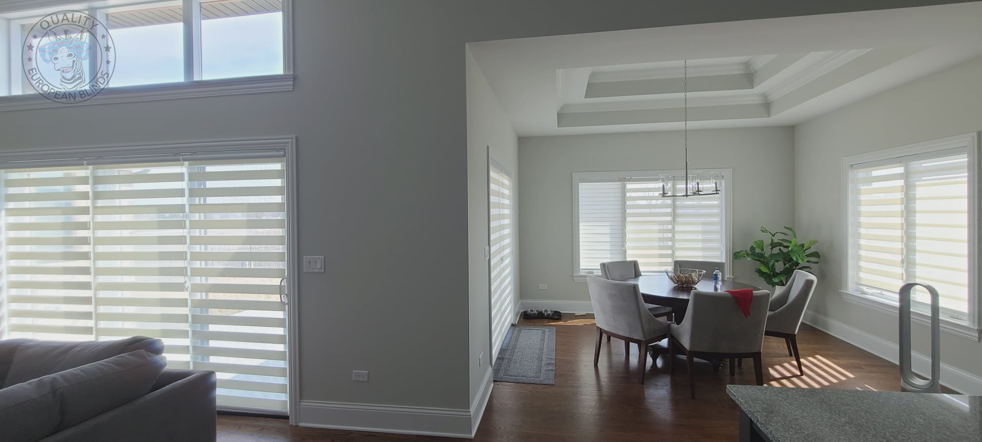 White zebra blinds installed throughout an open dining room